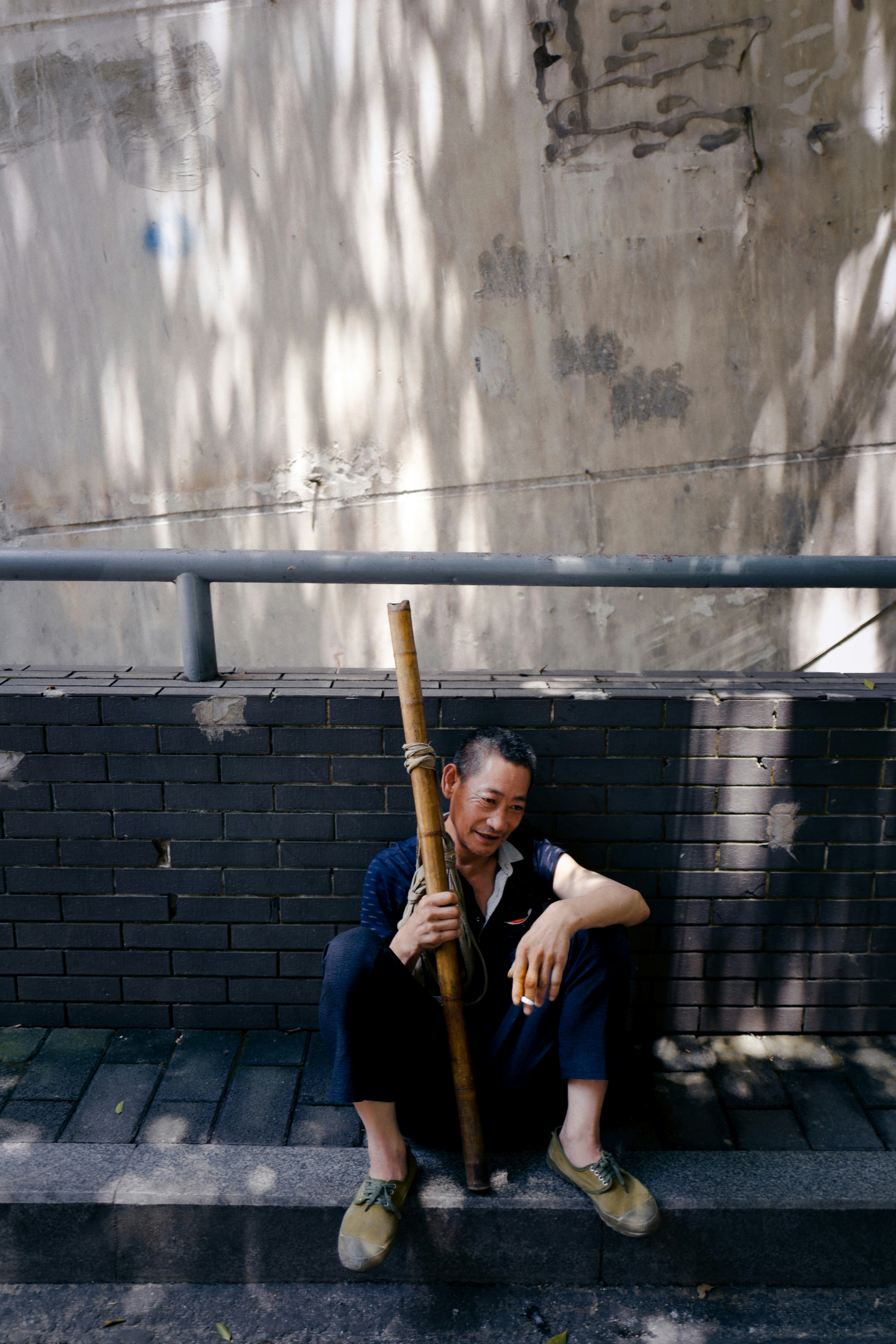 man in black shirt holding brown stick